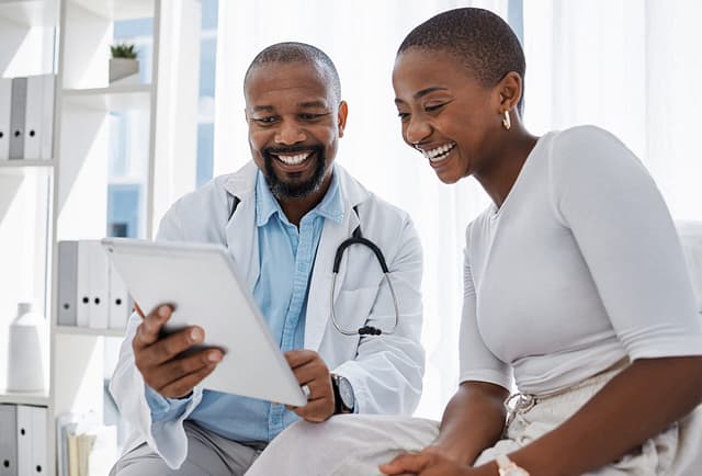 Doctor consulting smiling patient with tablet